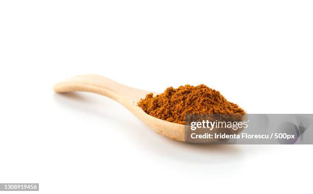 close-up of ground spice in spoon against white background - pepper seasoning stock pictures, royalty-free photos & images