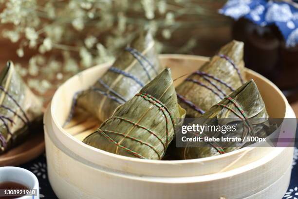 close-up of food wrapped in leaves on table - dragon boat stock pictures, royalty-free photos & images