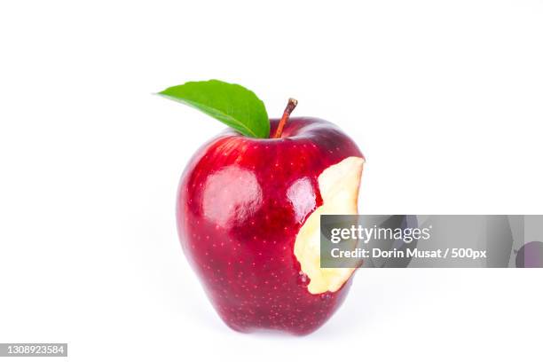 close-up of wet apple against white background - angebissen stock-fotos und bilder