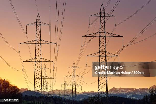 low angle view of silhouette of electricity pylon against sky during sunset,agasul,switzerland - electricity pylon bildbanksfoton och bilder