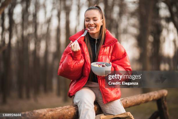 beautiful female hiker taking a break and eating salad. woman hiker hiking on sunrise mountain peak - young woman with backpack rise to the mountain top.  discovery travel destination - extreme dieting stock pictures, royalty-free photos & images