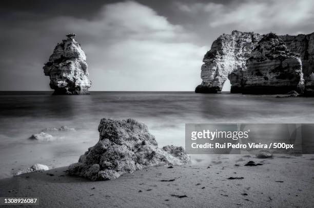 scenic view of rock formation in sea against sky,praia da marinha,lagoa,portugal - férias 個照片及圖片檔