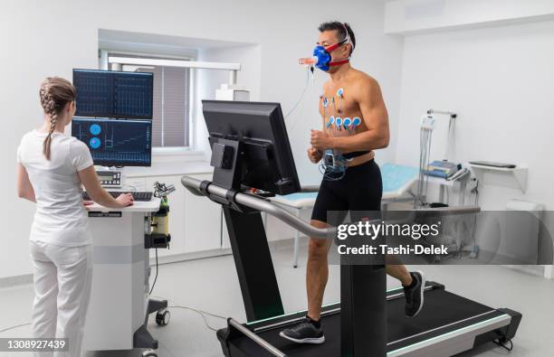atleta masculino realizando prueba ecg y vo2 en cinta de correr - sistema-cardiopulmonar-humano fotografías e imágenes de stock