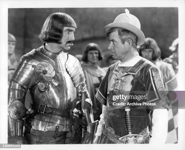 Will Rogers looking at unidentified knight in a scene from the film 'A Connecticut Yankee', 1931.