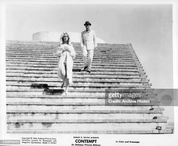 Brigitte Bardot and Michel Piccoli walking down stairs in a scene from the film 'Contempt', 1963.