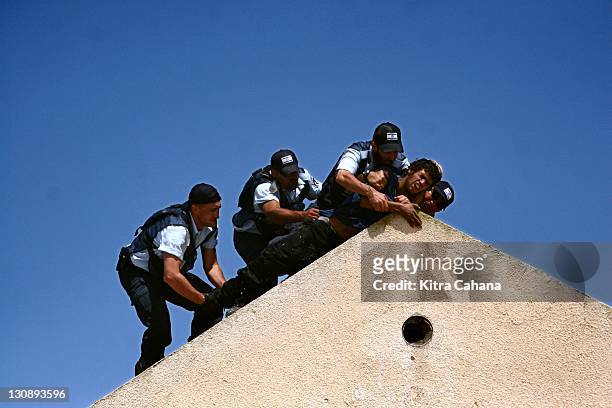 In a rash moment, a young Jewish settler threatens Israeli police officers that if they attempt to evacuate him, he will jump off the edge of his...
