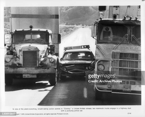 Two trucks crush police car in a scene from the film 'Convoy', 1978.
