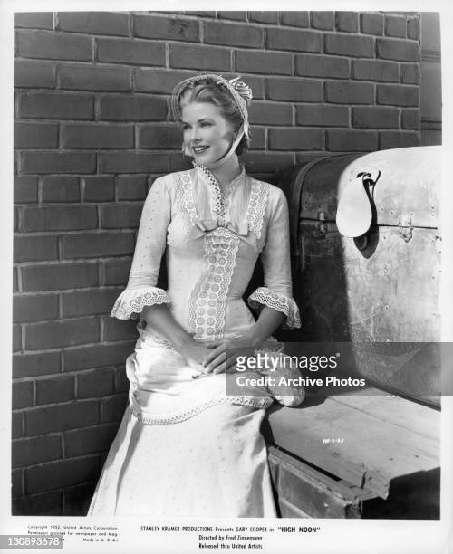 Grace Kelly standing near brick wall in a scene from the film 'High Noon', 1952.