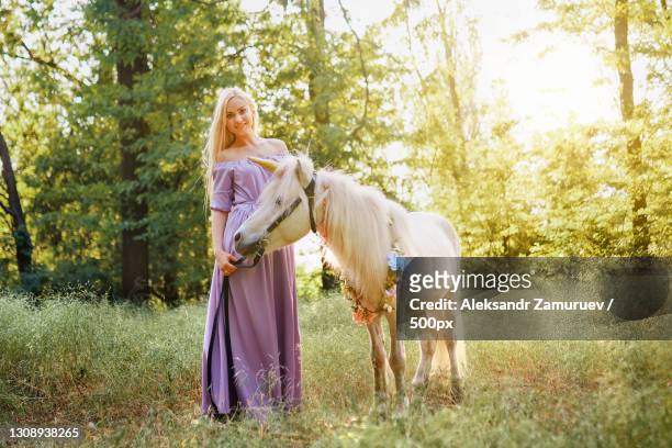 woman with horse standing on field - the fairy queen stock pictures, royalty-free photos & images