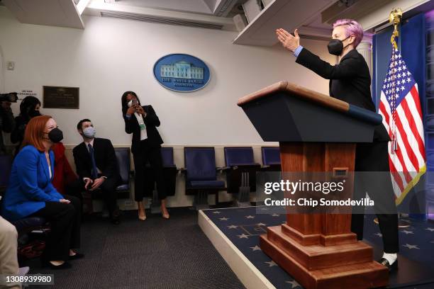 Professional soccer player Megan Rapinoe pretends to call on journalists as White House Press Secretary Jen Psaki looks on in the Brady Press...