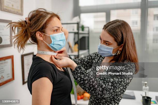 dietitian holding diet plan during consultation with patient in the office - nutrition coach stock pictures, royalty-free photos & images