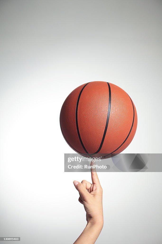 Basketball on index finger,hands close-up