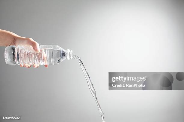 hand pouring water from bottle,hand close-up - bouteille d'eau photos et images de collection