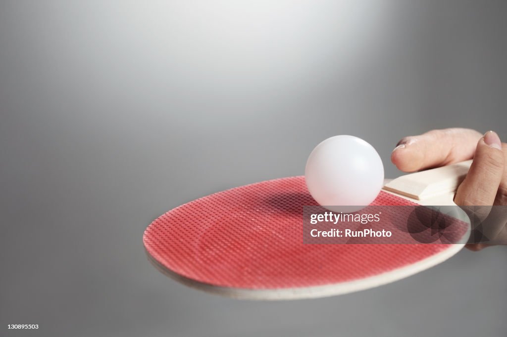 Hand holding table tennis paddle&ball