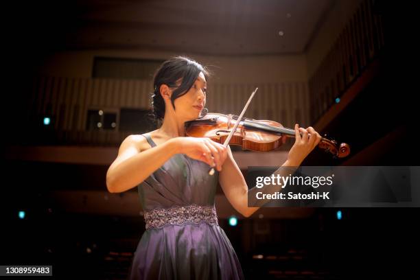 donna che suona il violino al concerto di musica classica - orchestra foto e immagini stock