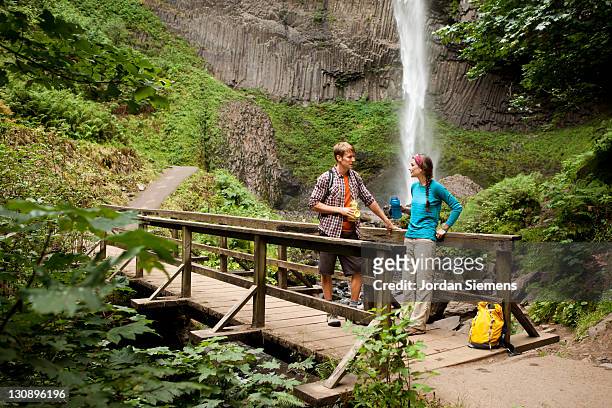 a couple hiking near waterfalls. - portland oregon columbia river gorge stock pictures, royalty-free photos & images