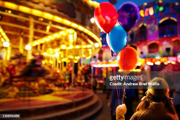 young girl holding balloons at the fairground - kingston upon hull stock-fotos und bilder