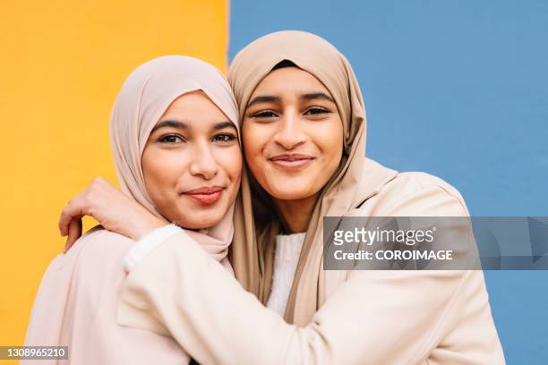 two arab female friends hugging each other outdoors. - moroccan girls bildbanksfoton och bilder