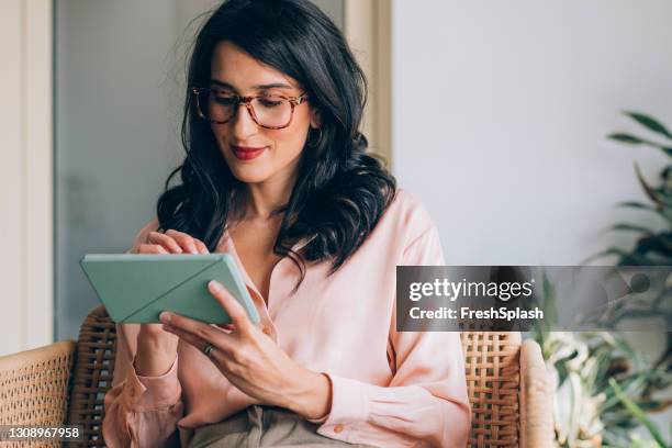 glückliche geschäftsfrau mit einem digitalen tablet bei der arbeit - grünes hemd stock-fotos und bilder