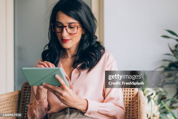 gelukkige onderneemster die een digitale tablet bij het werk met behulp van - groen shirt stockfoto's en -beelden