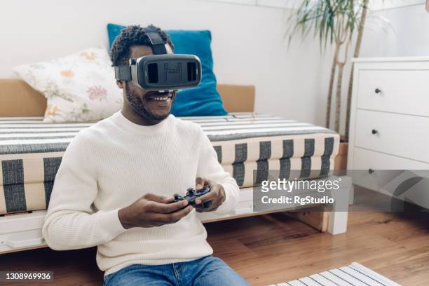 アフリカ系アメリカ人男性のゲームとバーチャルリアリティヘッドセットを使用 - flying goggles ストックフォトと画像