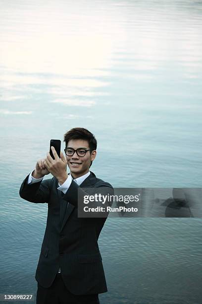 businessman touching a mobile phone in the lake - nagano 1998 stock pictures, royalty-free photos & images