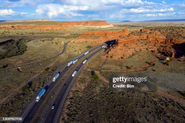 trucks on highway between red rocks - new mexico imagens e fotografias de stock