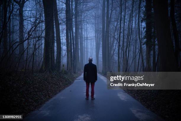 middle aged man alone in misty forest, lonely and abandoned in gloomy atmospheric mood - back to the past stock pictures, royalty-free photos & images