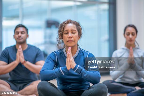 senior african female adult at meditation class - black woman yoga stock pictures, royalty-free photos & images