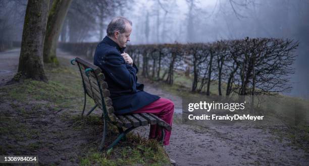 mirando a lo lejos, un hombre de mediana edad solo en bosque brumoso, solo y abandonado en un estado de ánimo atmosférico sombrío - viudo fotografías e imágenes de stock