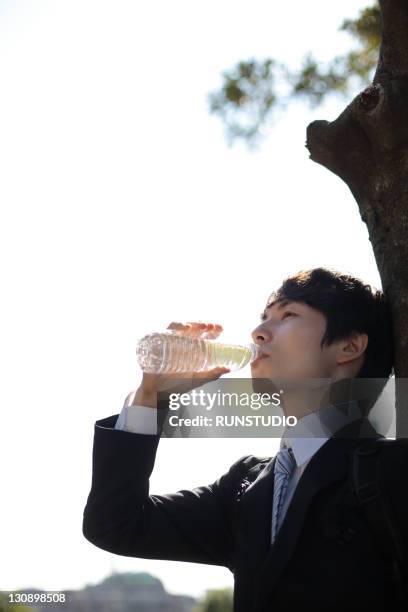 young businessman drinking water - durst stock-fotos und bilder