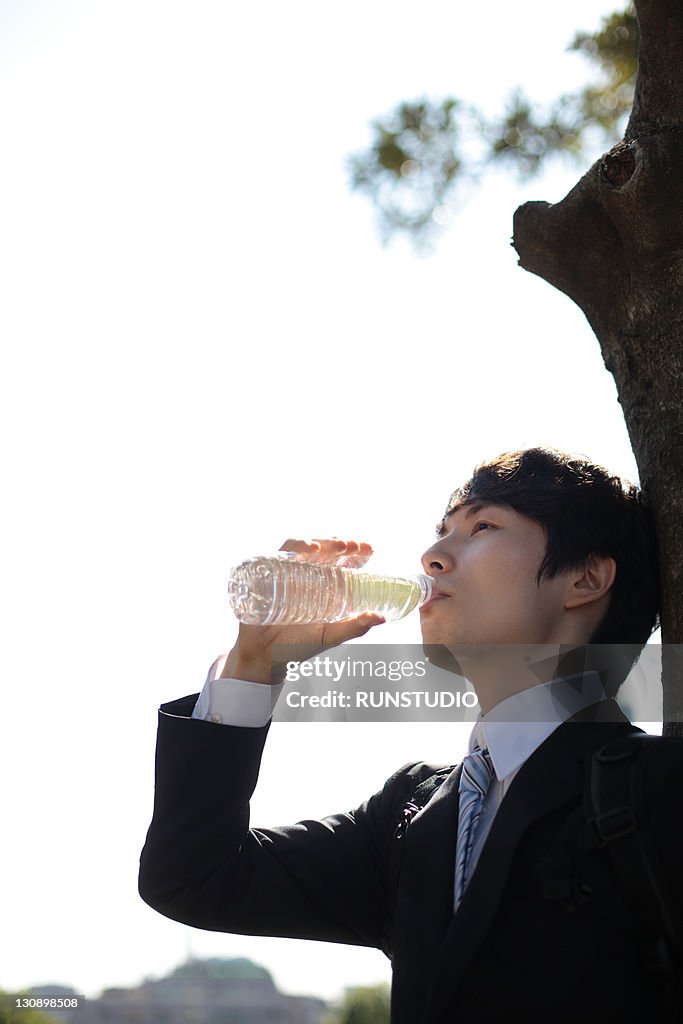 Young businessman drinking water