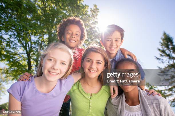 multi ethnic group of children posing for a photo outdoors - ymca stock pictures, royalty-free photos & images