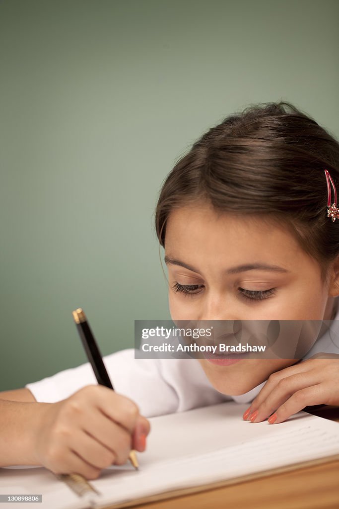 Happy schoolgirl writing her lessons