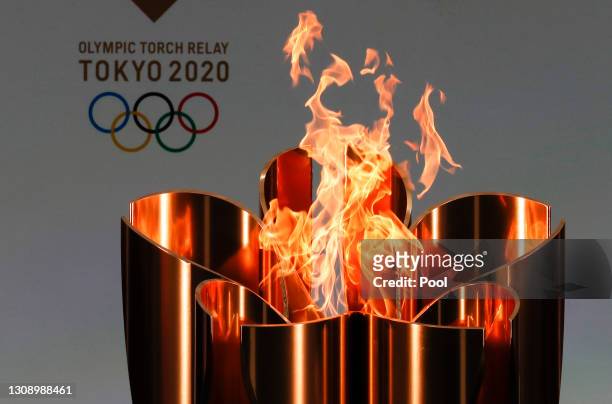 The celebration cauldron is lit during the opening ceremony ahead of the the first day of the Tokyo 2020 Olympic torch relay at the J Village during...
