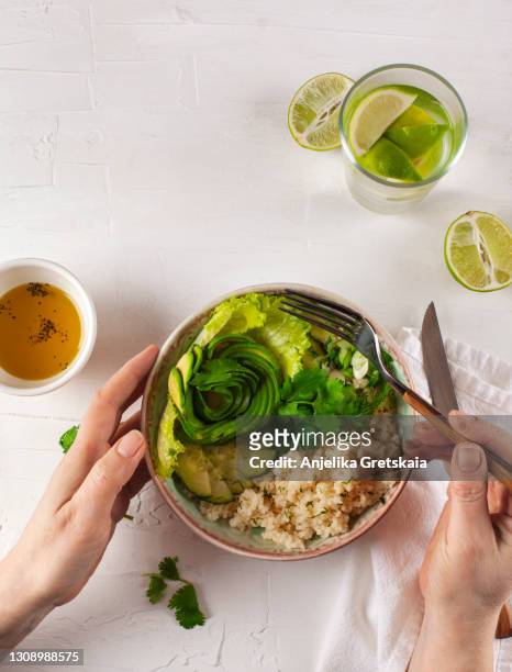 woman eating vegan salad. green salad with couscous and avocado. - avocato oil stock-fotos und bilder