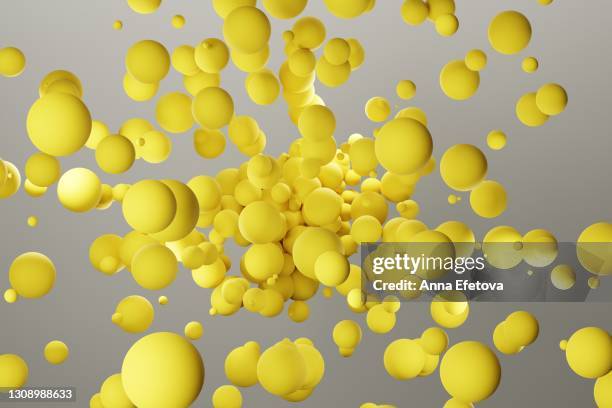 many yellow spheres splashing over gray background. demonstrating colors of the year 2021 - ultimate gray and illuminating - coloured balls stockfoto's en -beelden