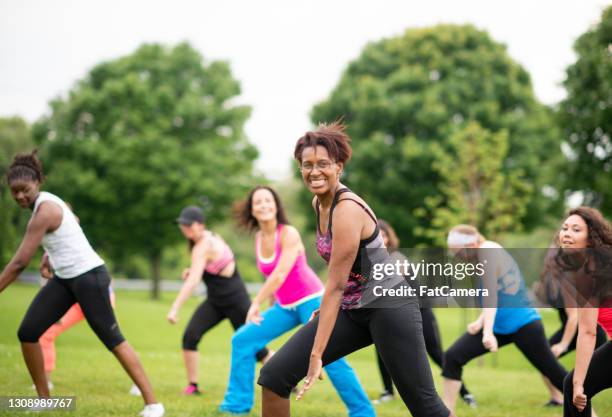 grupo multiétnico de mujeres en clase de zumba al aire libre - exercise class fotografías e imágenes de stock