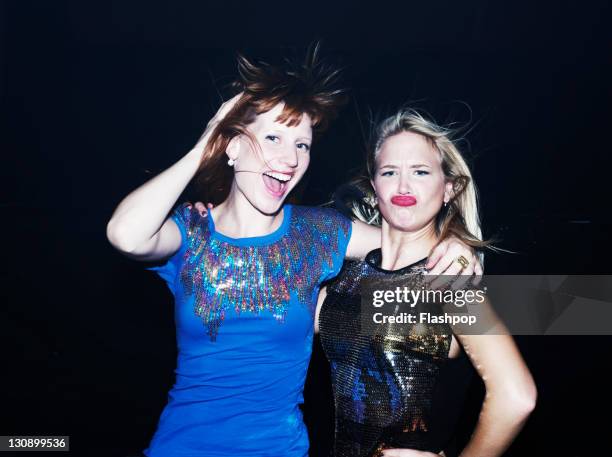 two women having fun together on night out - making a face stock-fotos und bilder