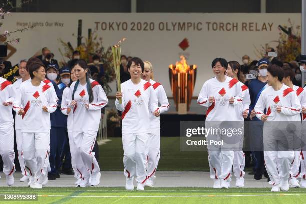 Azusa Iwashimizu and other members of the Japan women’s National Football Team "Nadeshiko Japan" run as torchbearers in the first leg of the torch...