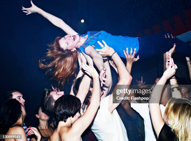 woman crowd surfing - crowd surfing stock-fotos und bilder