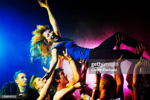 woman crowd surfing - crowd surfing stock pictures, royalty-free photos & images