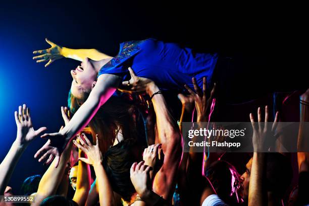 woman crowd surfing - crowd surfing stock-fotos und bilder