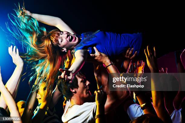 woman crowd surfing - crowd surfing stock-fotos und bilder