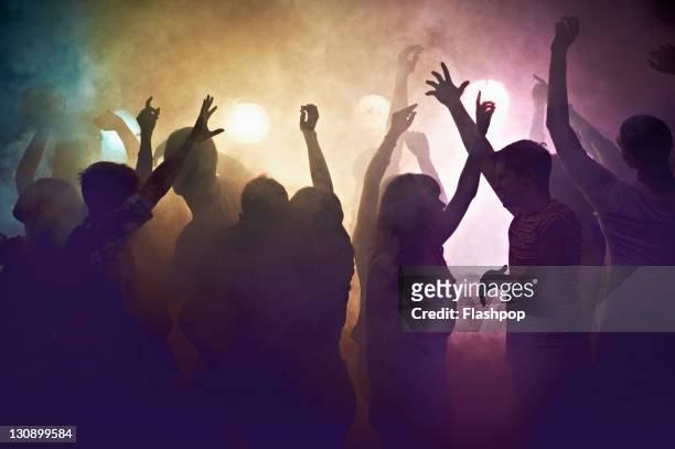 crowd of people at concert waving arms in the air - arts culture and entertainment stock-fotos und bilder