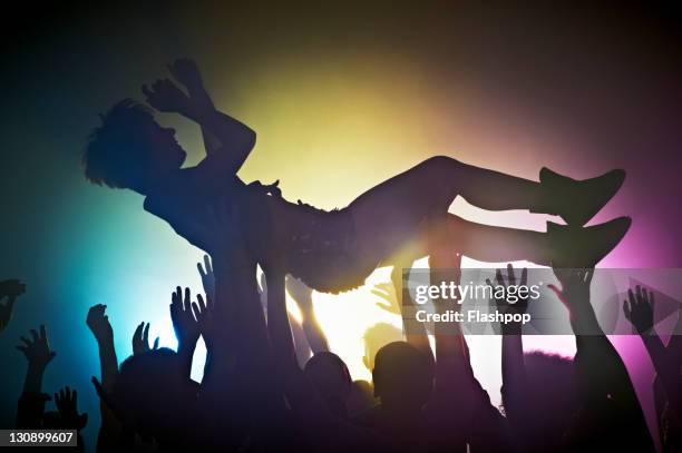woman crowd surfing - être-porté-par-la-foule photos et images de collection