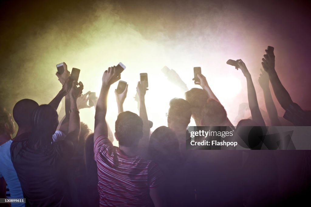 Crowd of people at concert using mobile phones