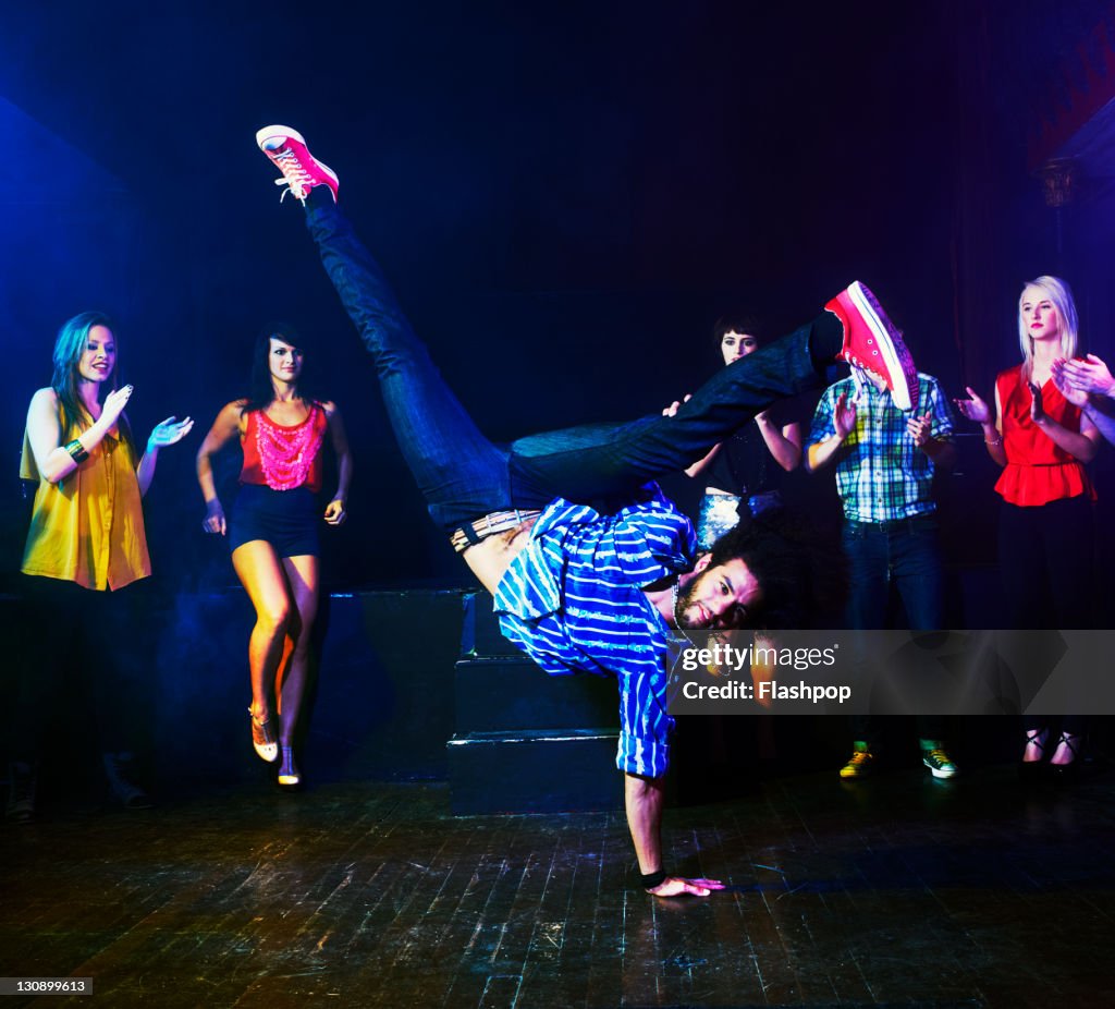 Man dancing in front of a crowd of people