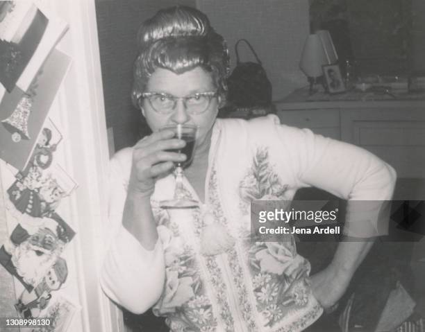 funny grandmother wearing wig and drinking alcohol at holiday party 1950s vintage photograph - old fashioned drink stock pictures, royalty-free photos & images
