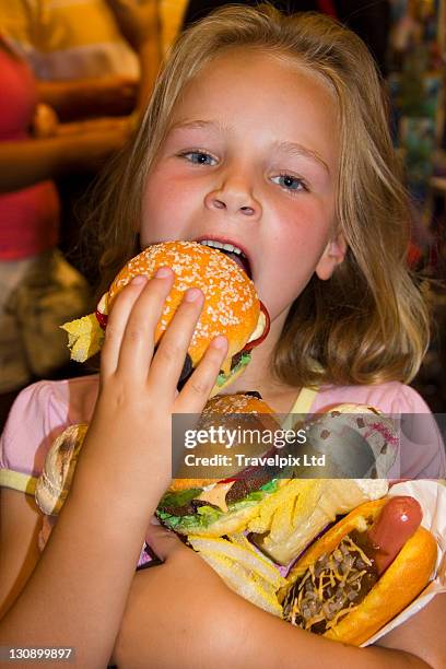 6 year old girl eating junk food - chubby girl stock-fotos und bilder